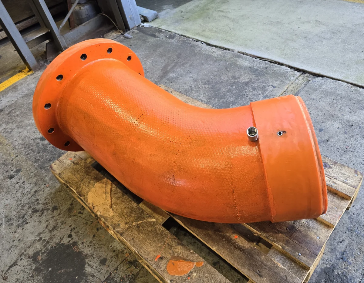 A large moulded polyurethane pipe elbow with a flanged inlet