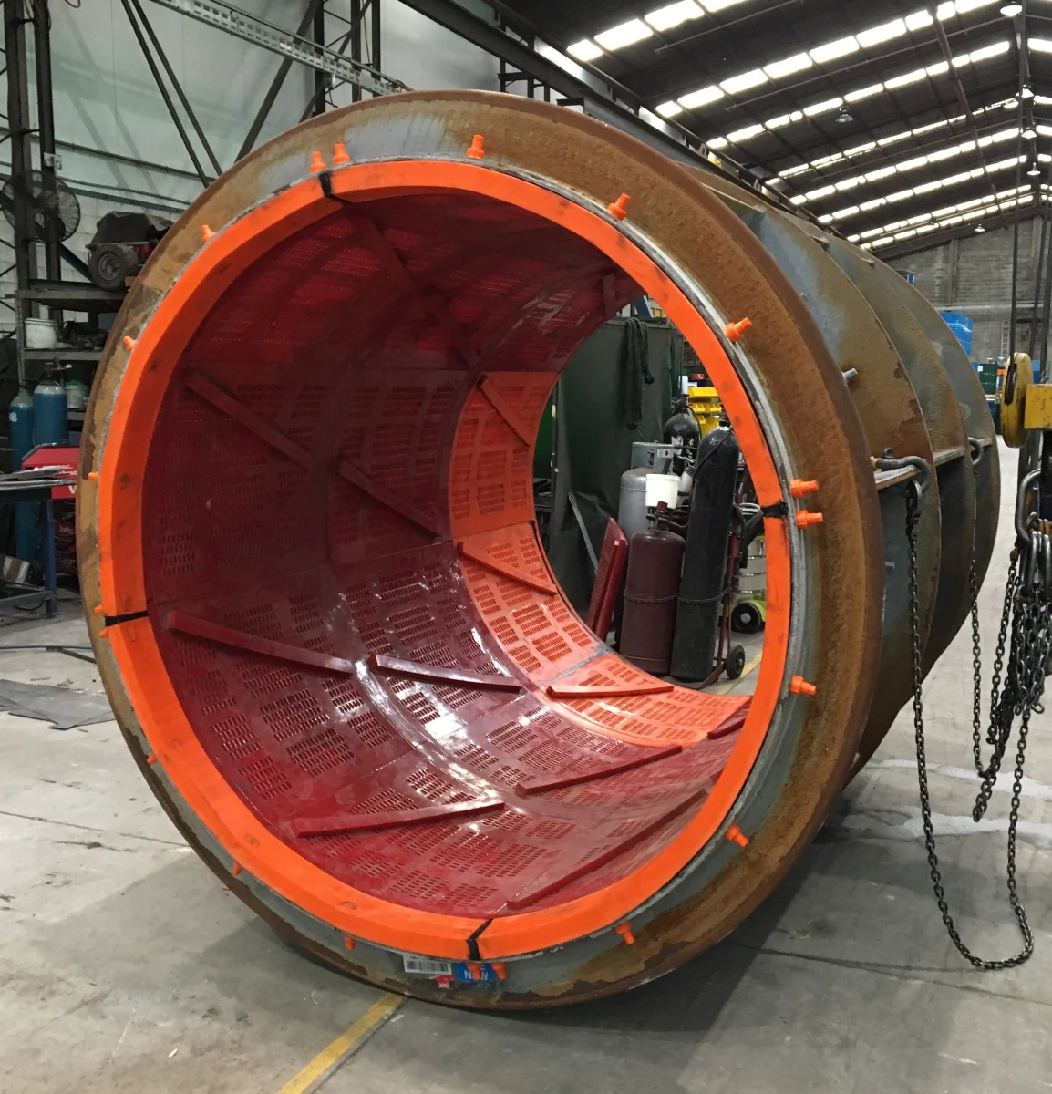 A trommel drum being lined with moulded polyurethane screen panels in the UMA workshop
