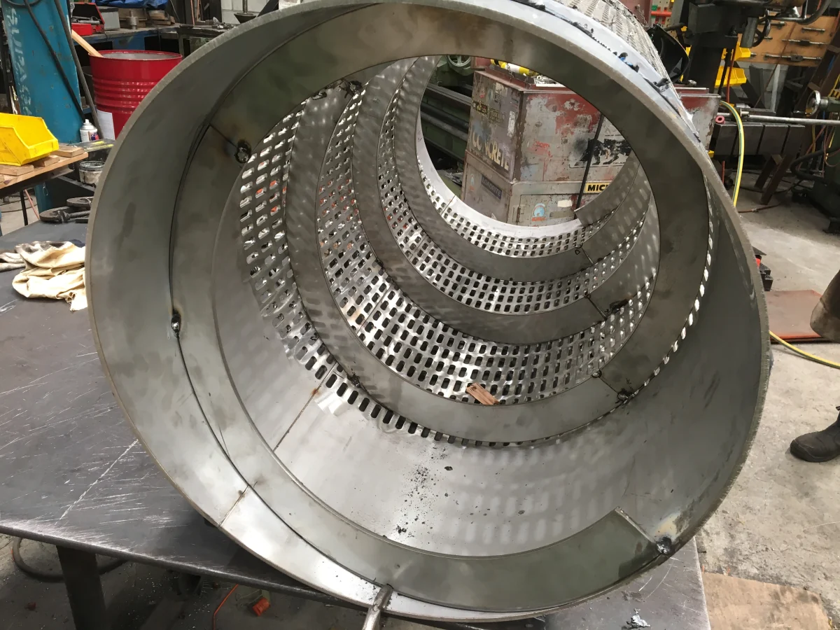 A steel trommel drum shell prepared for lining, showing its perforated screen sections