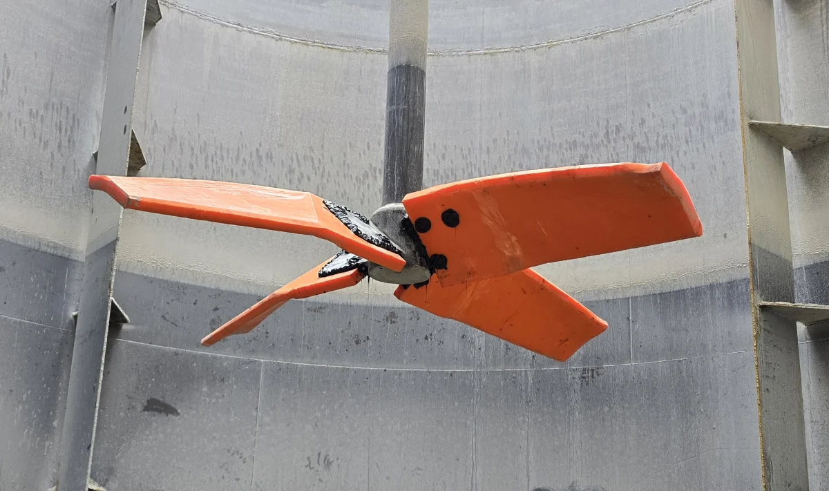 A polyurethane-lined agitator mixer blade inside a tank